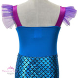Girl's Little Mermaid style costume with shiny blue scale-print skirt, purple cap sleeves, and flared purple tulle tail fin back view