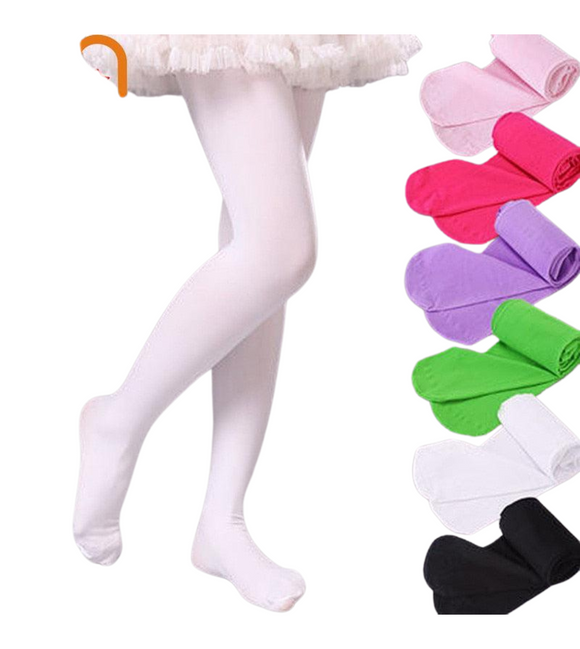 A young dancer wearing white ballet tights stands on one leg, with various colored tights rolled up in the background, including pink, red, purple, green, white, and black, showcasing the range of colors available for these versatile, stretchy girls' tights.