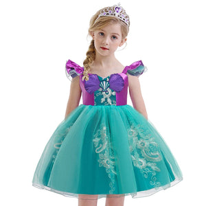 Little Mermaid-inspired special occasion dress for girls in purple and teal with seashell details, flowing tulle skirt, and optional tiara and magic wand accessories. Perfect for birthdays, costume parties, and dress-up play.